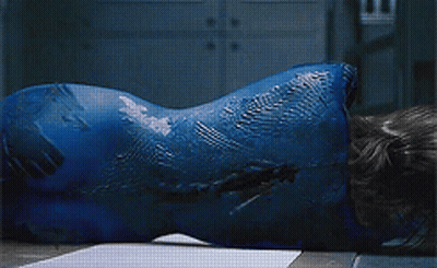 A Woman With Blue Paint On Her Face Is Laying On The Floor GIF