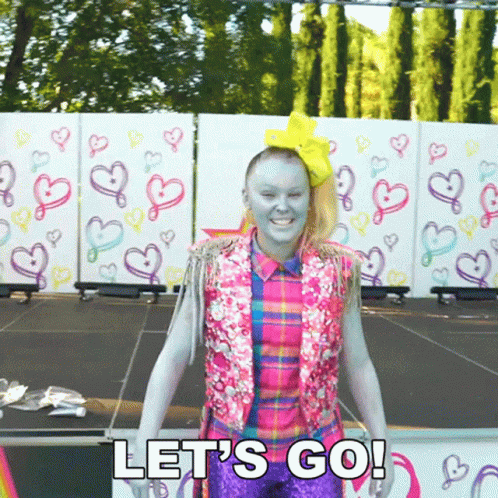 A Woman With Blue Paint On Her Face Is Standing On A Stage And Says Let 'S Go ! GIF