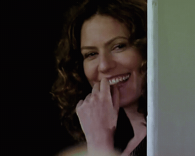 A Woman With Braces On Her Teeth Is Laughing GIF