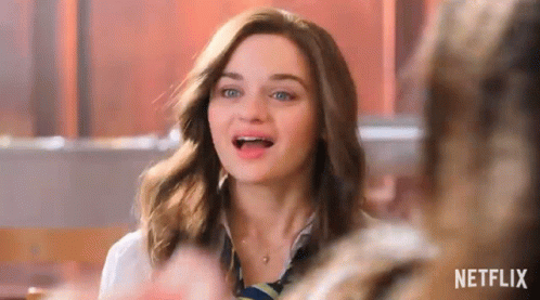 A Woman With Braces On Her Teeth Is Sitting At A Table In A Restaurant . GIF