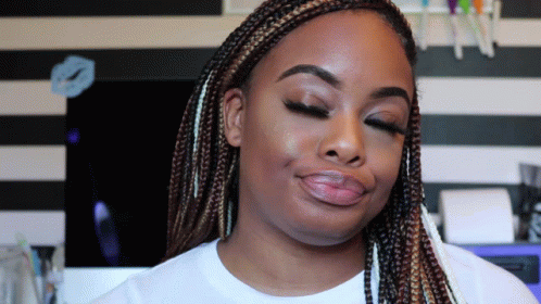 A Woman With Braids Has Her Eyes Closed And A White Shirt On GIF