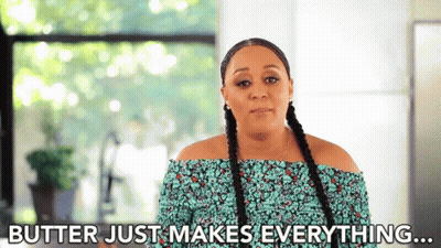 A Woman With Braids Is Standing In Front Of A Window And Saying `` Butter Just Makes Everything ... '' GIF