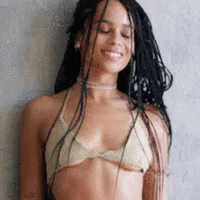 A Woman With Braids Is Wearing A Bikini Top And Smiling . GIF