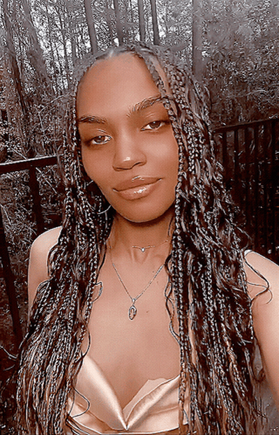 A Woman With Braids Is Wearing A Necklace GIF