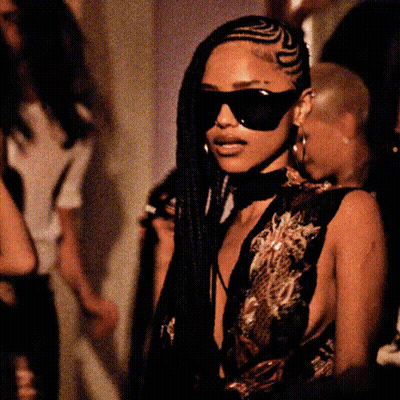 A Woman With Braids Wearing Sunglasses And A Choker Around Her Neck GIF