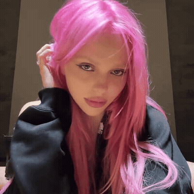 A Woman With Bright Pink Hair Is Wearing A Black Shirt GIF
