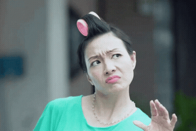 A Woman With Curlers In Her Hair Is Making A Face GIF