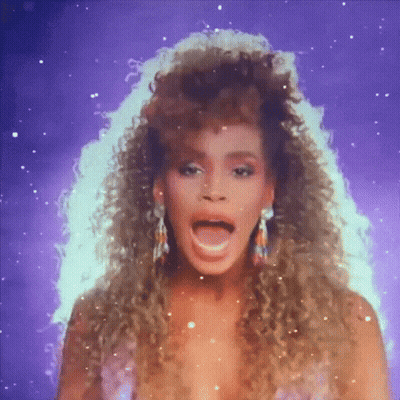A Woman With Curly Hair And Earrings Is Singing GIF