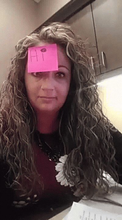 A Woman With Curly Hair Has A Sticky Note On Her Forehead That Says Hi GIF