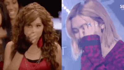 A Woman With Curly Hair Is Covering Her Mouth With Her Hand And A Woman With Blonde Hair Is Covering Her Face With Her H GIF