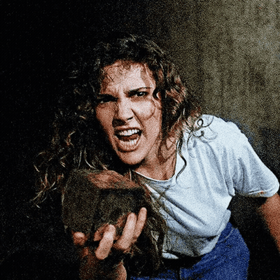 A Woman With Curly Hair Is Holding A Rock In Her Hands GIF
