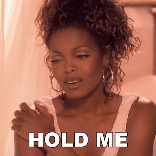 A Woman With Curly Hair Is Holding Her Hands Together With The Words Hold Me Below Her GIF