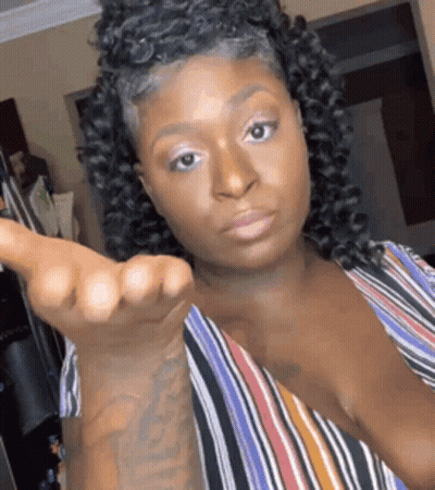 A Woman With Curly Hair Is Making A Funny Face And Giving A Middle Finger . GIF
