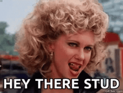 A Woman With Curly Hair Is Making A Funny Face And Saying Hey There Stud . GIF
