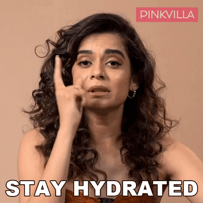 A Woman With Curly Hair Is Making A Funny Face And Says " Stay Hydrated " GIF