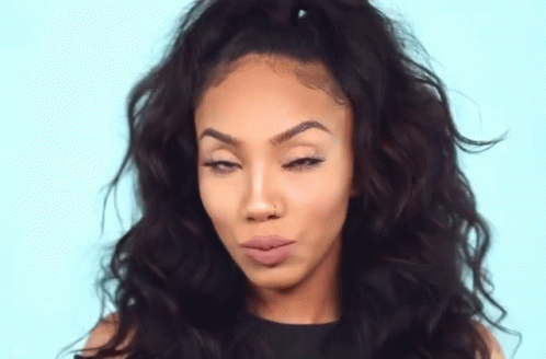 A Woman With Curly Hair Is Making A Funny Face With Her Eyes Closed . GIF