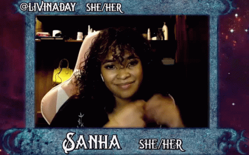 A Woman With Curly Hair Is Sitting In A Chair And Smiling In A Frame That Says Livinaday She / Her GIF