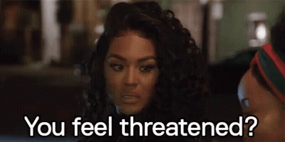 A Woman With Curly Hair Is Sitting Next To A Man . GIF