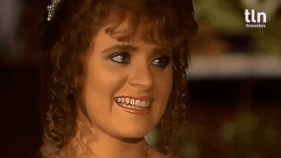 A Woman With Curly Hair Is Smiling With A Tln Logo In The Background . GIF