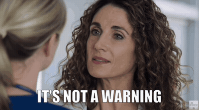 A Woman With Curly Hair Is Talking To Another Woman Who Says It 'S Not A Warning . GIF