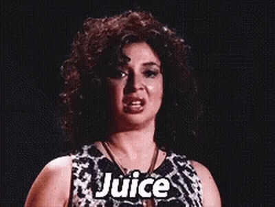 A Woman With Curly Hair Is Wearing A Black And White Dress And Necklace And Says Juice . GIF