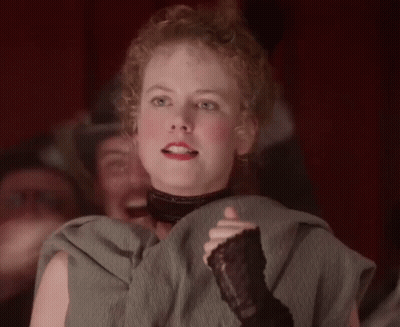 A Woman With Curly Hair Is Wearing A Black Glove GIF