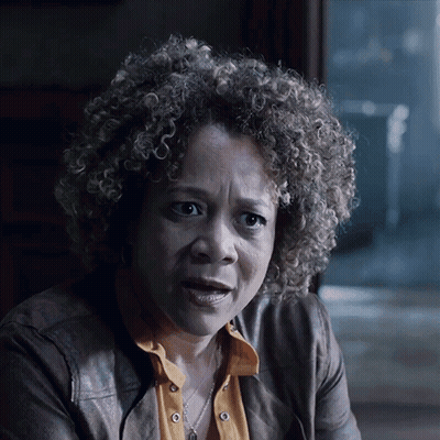 A Woman With Curly Hair Is Wearing A Leather Jacket GIF