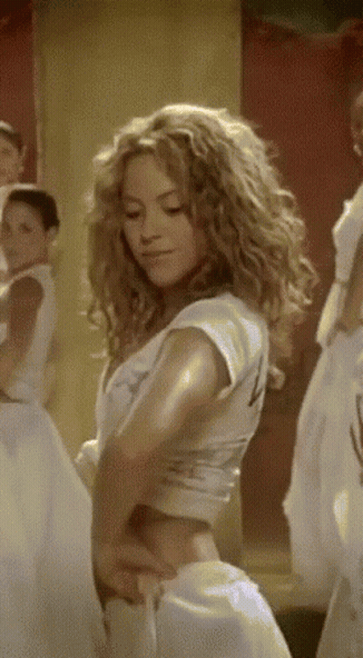 A Woman With Curly Hair Is Wearing A White Crop Top With The Number 4 On It GIF
