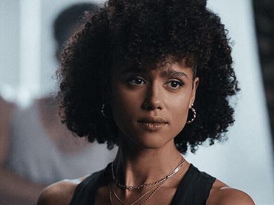 A Woman With Curly Hair Is Wearing Hoop Earrings GIF