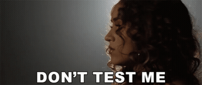A Woman With Curly Hair Says " Do N't Test Me " In White Letters GIF
