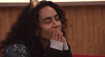 A Woman With Curly Hair Wearing A Headband With A Gold Bow On It GIF