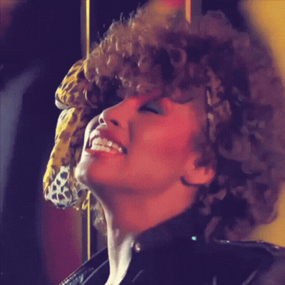A Woman With Curly Hair Wearing A Leopard Print Headband GIF