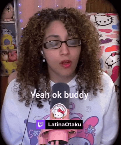 A Woman With Curly Hair Wearing Glasses And A Hello Kitty Shirt Says " Yeah Ok Buddy " GIF