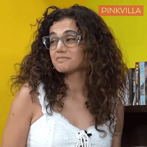 A Woman With Curly Hair Wearing Glasses And A White Tank Top With A Pinkvilla Logo In The Corner GIF