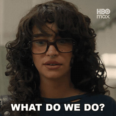 A Woman With Curly Hair Wearing Glasses Says What Do We Do GIF