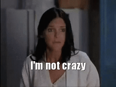 A Woman With Dark Hair Is Sitting In Front Of A Refrigerator And Says `` I 'M Not Crazy '' . GIF
