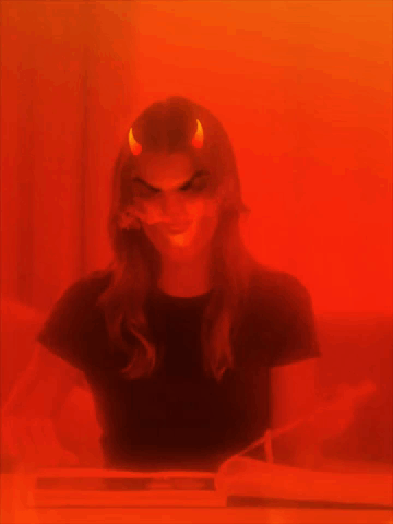A Woman With Devil Horns On Her Head GIF