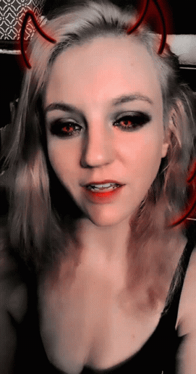 A Woman With Devil Horns On Her Head Is Taking A Selfie GIF