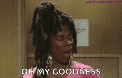 A Woman With Dreadlocks And Earrings Is Standing In A Doorway And Saying `` Oh My Goodness '' . GIF