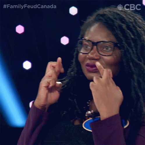 A Woman With Dreadlocks And Glasses Is Making A Face With Her Fingers GIF