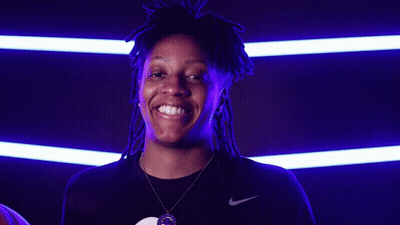 A Woman With Dreadlocks Is Holding A Basketball And Smiling For The Camera GIF