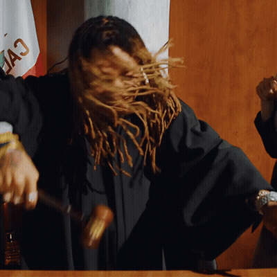 A Woman With Dreadlocks Is Holding A Hammer In Front Of A Flag That Says " California " GIF