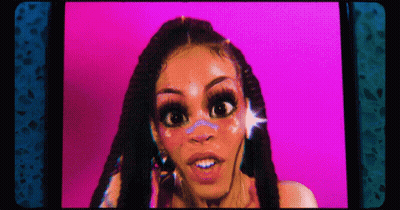 A Woman With Dreadlocks Is Looking At The Camera With A Pink Background . GIF