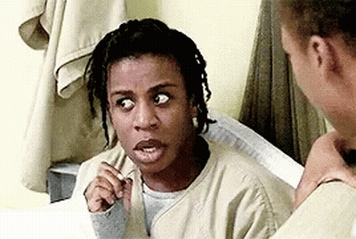 A Woman With Dreadlocks Is Sitting Next To A Man In A Prison Cell And Making A Funny Face . GIF