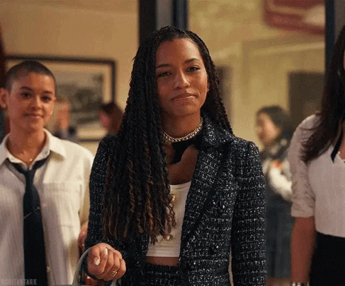 A Woman With Dreadlocks Is Standing Next To A Group Of Women In Suits And Ties . GIF