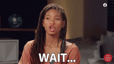 A Woman With Dreadlocks Says Wait On A Red Table Talk Advertisement GIF