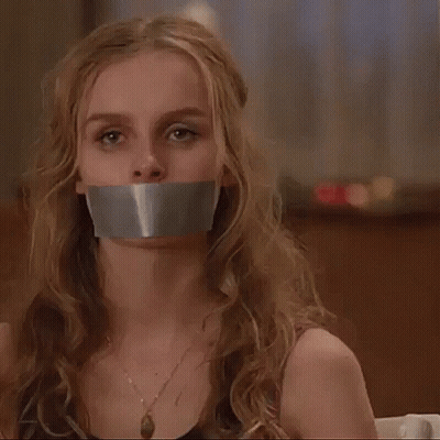 A Woman With Duct Tape On Her Mouth Is Sitting In A Chair . GIF