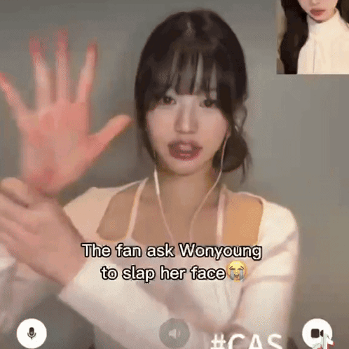 A Woman With Ear Buds Holds Her Hand Up In Front Of Her Face And Says The Fan Ask Wonyoung To Slap Her Face GIF