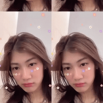 A Woman With Flowers On Her Face Is Looking At The Camera GIF