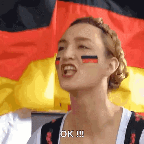 A Woman With German Flags Painted On Her Face Says Ok GIF